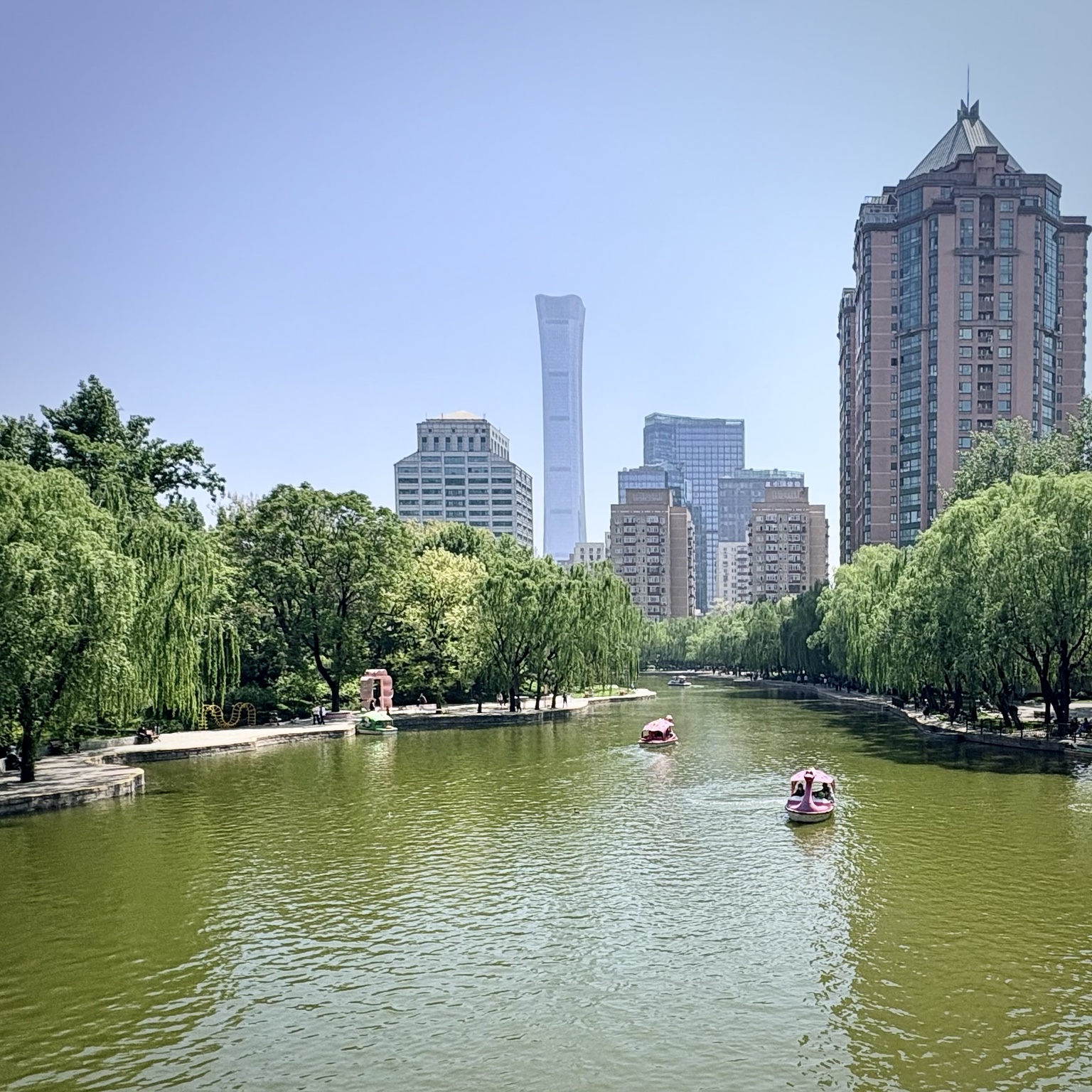 Le plan d’eau et les arbres du parc Tuanjiehu, avec les grands immeubles de Pékin à l’arrière-plan